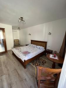 Un dormitorio con una cama grande y una mesa. en La Mona, en Bîrsana