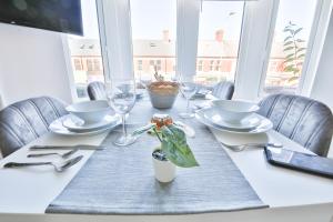 a dining room table with a white table set with glasses at 1 bedroom apartment near Cardiff Town Centre in Cardiff