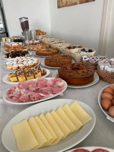 Hotel Tre Stelle Gabicce Mare في غابيتّشي ماري: طاولة مع العديد من الأنواع المختلفة من الكعك والمعجنات