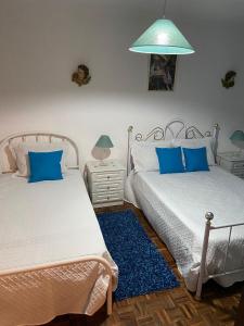 a bedroom with two beds and a blue rug at Cacho D'ouro in Santa Marta de Penaguião