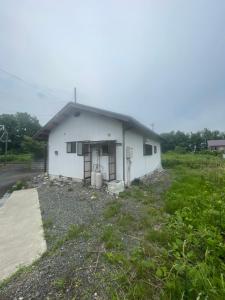 a small white building with a yard in front of it at 高島市一棟貸切 貸別荘グループファミリーok 大人数でご利用だとお得連泊がお得BBQ可能自転車無料利用可 in Takashima