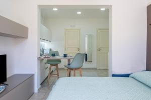 sypialnia z łóżkiem i 2 krzesłami oraz kuchnia w obiekcie Majolica Home w mieście San Gregorio di Catania