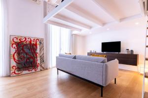 a living room with a couch and a tv at Oliveri Vintage House at Politeama in Palermo