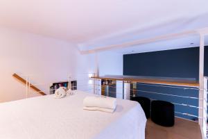 a bedroom with a white bed with two towels on it at Oliveri Vintage House at Politeama in Palermo