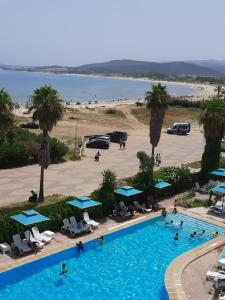 uma vista superior de uma piscina ao lado de uma praia em corail royal hotel em Tabarka