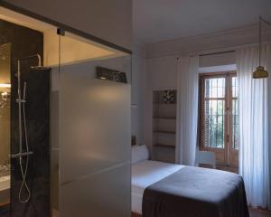 a small bedroom with a bed and a shower at Guest House Ibaia Et Arramak in San Sebastián