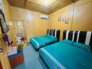 a small room with two beds in a room at Perhentian Sri Tanjung , Pulau Perhentian in Perhentian Island