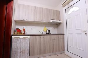 a kitchen with wooden cabinets and a sink next to a door at Para Thin Alos in Polychrono