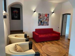sala de estar con sofá rojo y silla roja en Villa - un air Marin, en Tourrettes-sur-Loup