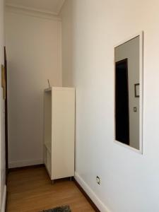 a white room with a cabinet and a mirror at Pensao Central in Matosinhos
