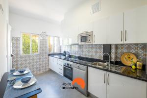 uma cozinha com armários brancos e um micro-ondas em #049 Spacious OldTown with AC, Pool, 150 mts Beach em Albufeira