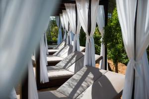 een rij witte stoelen met witte gordijnen bij Suites Natura Mas Tapiolas in Santa Cristina d'Aro