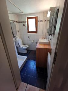 y baño con 2 aseos, lavamanos y espejo. en Ca da Lovi, en Cerentino