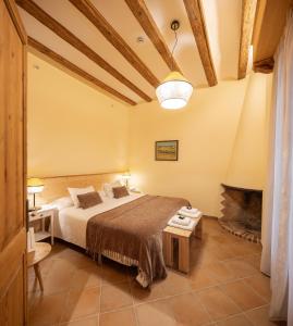 a bedroom with a bed and a fireplace at Can Passarells in San Vicente de Torelló