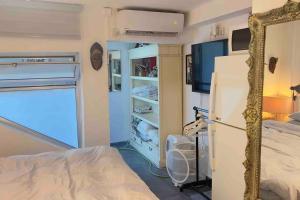 a bedroom with a bed and a mirror and a refrigerator at Studio in the best place of town! in Tel Aviv