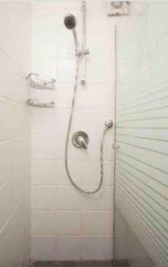 a shower with a hose attached to a wall at Studio in the best place of town! in Tel Aviv