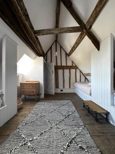 an attic room with a bed and a rug at Cosy Cottage in Lechlade in Lechlade