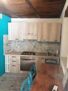 Appartamento Severino - Rariche House في كاميروتا: مطبخ بدولاب خشبي وطاولة ومغسلة