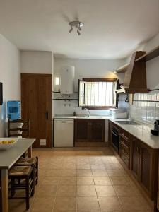 eine große Küche mit einem Waschbecken und einem Tisch in der Unterkunft Casa Buganvilla con piscina en San José Sotillo in San José