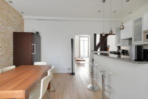 a kitchen with a wooden table and white cabinets at Appartement Neuf Saint-Honoré - Tuileries in Paris