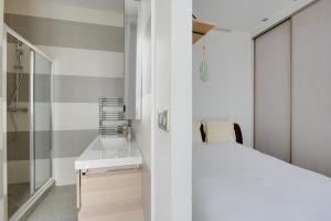 a bedroom with a white bed and a shower at Appartement Neuf Saint-Honoré - Tuileries in Paris