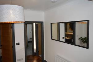 a living room with a mirror and a lamp at Three Oaks in Winkleigh