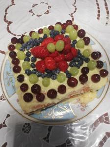 um pedaço de bolo com fruta em cima de um prato em B&B Chez Elisabeth em Pádua