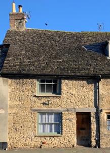 an old brick building with a window and a roof at Cosy Cottage in Lechlade in Lechlade