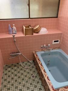 y baño alicatado de color rosa con bañera. en Nagano - House - Vacation STAY 14590, en Nagano