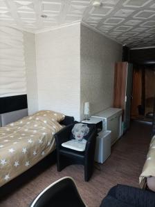 ein Hotelzimmer mit einem Bett und einem Stuhl mit einem Teddybär in in der Unterkunft Fitness Pension in Sulingen