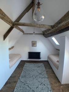 a attic room with two beds and a rug at Cosy Cottage in Lechlade in Lechlade