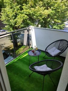 eine Terrasse mit 2 Stühlen und einem Tisch auf dem Balkon in der Unterkunft Apartman Golemovic in Banja Luka