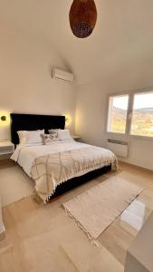 1 dormitorio con cama grande y ventana grande en Thinissut Guest House, en Ouled Salem