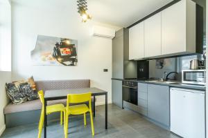 a kitchen with a table and yellow chairs in a kitchen at Viral 2 BR Photo Studio Loft in Sofia