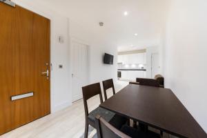 a dining room with a table and chairs and a door at Stylish 2 bedroom Apartment in Central london in London