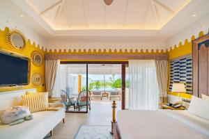 a bedroom with a bed and a living room at SAii Lagoon Maldives, Curio Collection By Hilton in South Male Atoll