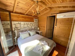 a bedroom with a bed in a log cabin at Aral Turkuaz in Cesme