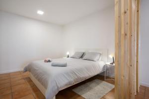 een slaapkamer met een groot wit bed in een kamer bij Babosas Charm in Funchal