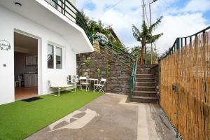 a house with a green lawn in the backyard at Babosas Charm in Funchal