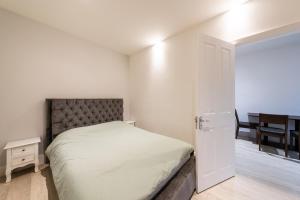 a bedroom with a bed and a door to a dining room at Stylish 2 bedroom Apartment in Central london in London