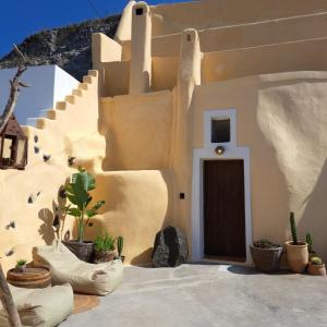 a small house with a door and some plants at Caval I in Fira