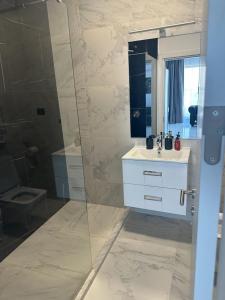 a bathroom with a white sink and a shower at Koya Tower by Lake Mamaia in Mamaia