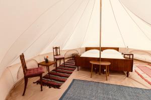 a room with a tent with a bed and chairs at Bygagergaard in Askeby