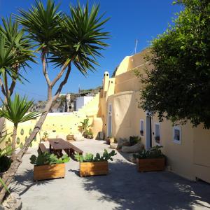 a courtyard with palm trees and a building at Caval I in Fira