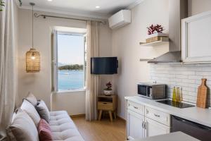 ein Wohnzimmer mit einem Sofa und einer Mikrowelle in der Unterkunft Fotiadis Family Luxury Suites by Konnect in Korfu-Stadt