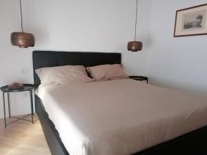 ein Bett in einem Schlafzimmer mit zwei Lichtern darüber in der Unterkunft La chicca di Plinio in Mailand
