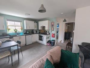 eine Küche und ein Wohnzimmer mit einem Sofa und einem Tisch in der Unterkunft Namastay-Central Glastonbury in Glastonbury