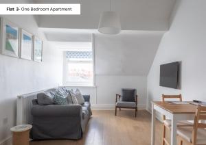 a living room with a couch and a table at The Chymes Holiday Flats in Lytham St Annes