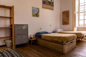 a room with two beds in a room at Hostel Albergue La Casa Encantada in El Paso