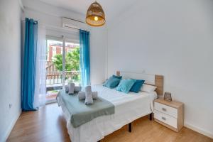 a bedroom with a bed and a window with blue curtains at LXR Vistahermossa 3BDR. Apt Next to sea in Fuengirola